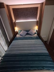 a bed with two pillows on it in a room at Luxury Pods at Mornest Caravan Park, Anglesey in Gaerwen