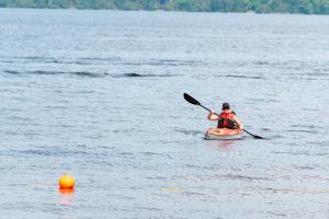 a person in a kayak on a lake at Newly Renovated 2 Bedroom Beach Front Condo 2A in Lanark