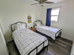 a bedroom with two beds and a ceiling fan at Newly Renovated 3 Bedroom Beach Front Condo 3B in Lanark