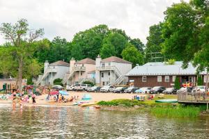 a group of people on a beach near a body of water at Newly Renovated 3 Bedroom Beach Front Condo 3B in Lanark