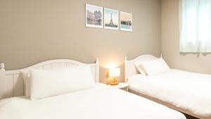 2 weiße Betten in einem Schlafzimmer mit Fenster in der Unterkunft Incheon Airport Guest House King in Incheon