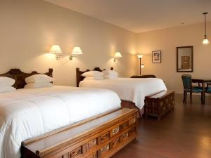 um quarto de hotel com duas camas e uma mesa em La Tourelle Hotel & Spa em Ithaca