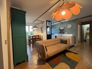 a living room with a couch and a dining room at Les Rives Rémoises in Reims