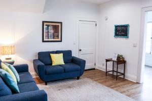 een woonkamer met een blauwe bank en een tafel bij Downtown Retreat - 2BR Oasis with Parking in Columbus
