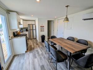 uma cozinha e sala de jantar com uma mesa de madeira e cadeiras em Newly Renovated 3 Bedroom Beach Front Condo 1B em Lanark