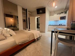 罗兹Apartament I LOVE PIOTRKOWSKA z wielkim lustrem, balkonem i klimatyzacją的一间带床和桌子的卧室和一间厨房