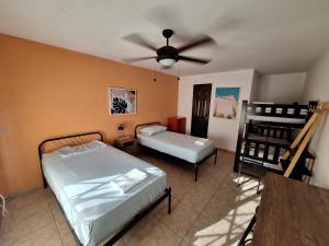 a bedroom with two beds and a ceiling fan at Casa Del Mar Pedasí in Pedasí Town