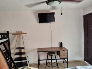 a room with a desk and a television on a wall at Casa Del Mar Pedasí in Pedasí Town