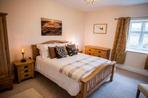 a bedroom with a large bed and a window at Abbey Farmhouse 