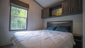 ein Schlafzimmer mit einem großen Bett und einem Fenster in der Unterkunft 2 Bedroom Cottage Tamarack Trail 1 in Campbellford