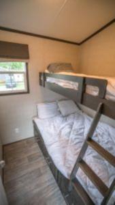 ein Schlafzimmer mit einem Etagenbett in einem Zimmer in der Unterkunft 2 Bedroom Cottage Tamarack Trail 1 in Campbellford