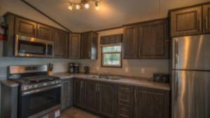 une cuisine avec des armoires en bois et un réfrigérateur en acier inoxydable dans l'établissement 2 Bedroom Cottage Tamarack Trail 1, à Campbellford 2 autres photos