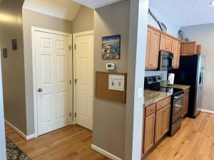 a kitchen with a white door and a stove top oven at Three Schooners Landing Condo 2 in Sodus Point
