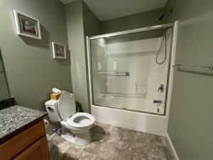 uma casa de banho com um chuveiro, um WC e uma banheira em Three Schooners Landing Condo 2 em Sodus Point