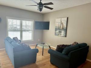 uma sala de estar com dois sofás e uma mesa em Three Schooners Landing Condo 2 em Sodus Point