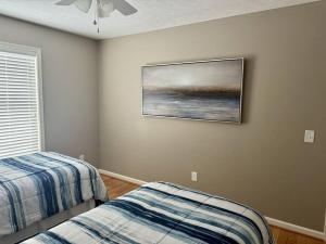 um quarto com duas camas e um quadro na parede em Three Schooners Landing Condo 2 em Sodus Point