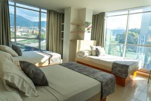 a hotel room with two beds and a large window at Hotel Alcaravan Medellín in Medellín