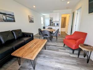 a living room with a couch and a table and chairs at Newly Renovated 2 Bedroom Beach Front Condo 2C in Lanark