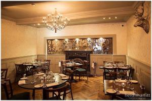a dining room with tables and chairs and a chandelier at Grassington House in Grassington