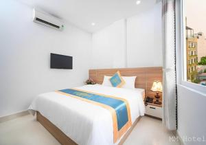a white bedroom with a bed and a window at Minh Minh Hotel & Spa in Da Nang