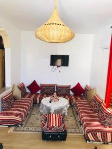 a living room with a couch and a table at Essaouira à louer, appartement avec piscine privée in Bou Mkila