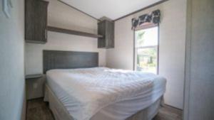 um quarto com uma cama branca e uma janela em 3 Bedroom Cottage Dragon Fly Drive 7 em Cherry Valley