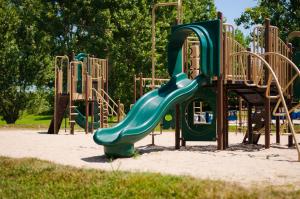 a playground with a green slide in a park at 3 Bedroom Cottage Dragon Fly Drive 7 in Cherry Valley