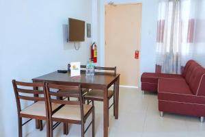 a living room with a table and chairs and a couch at MMaple Residences Talisay in Talisay