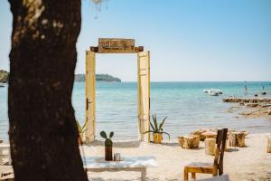 een boog op het strand met een tafel en stoelen bij Astraluxe in Fažana