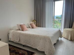 a bedroom with a bed with pink pillows and a window at L'abbaye Luxe et Vue Panoramique in Nice