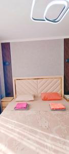 a bedroom with a bed with two pillows on it at Апартаменты Премиум-класса в Центре г.Семей in Semey +3 photos