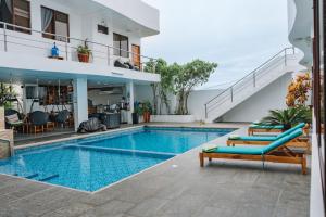 a swimming pool with two lounge chairs next to a house at El Descanso del Guia in Puerto Ayora