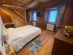 - une chambre avec un grand lit et un escalier dans l'établissement DRESALWOALD APPARTAMENTI, à Gressoney-Saint-Jean