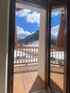 a door to a balcony with a view of the mountains at DRESALWOALD APPARTAMENTI in Gressoney-Saint-Jean