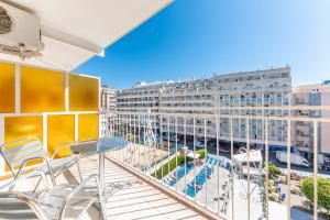 einen Balkon mit Stühlen, einem Tisch und einem Gebäude in der Unterkunft Port Vista Oro in Benidorm