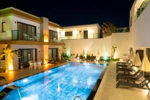 a swimming pool in front of a house at night at Milenyum Residence in Bodrum City