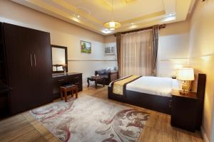 1 dormitorio con cama, escritorio y silla en Hotel Gardens view en Taif