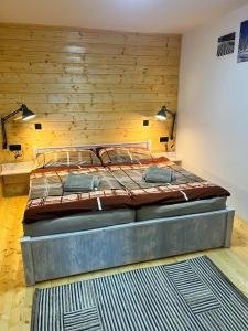 a large bed in a room with a wooden wall at Apartment Martin in Sonnenalpe Nassfeld