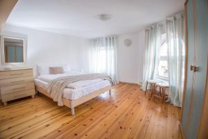 - une chambre blanche avec un lit et du parquet dans l'établissement 2BD in Heart of Plovdiv Top location, à Plovdiv