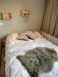 een bed met een harige deken en kussens erop bij Voyago room relax ride in Cadier en Keer