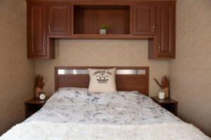 1 dormitorio con 1 cama grande y armarios de madera en 2 Bedroom Waterview Cottage Fern Brook 8, en Gravenhurst