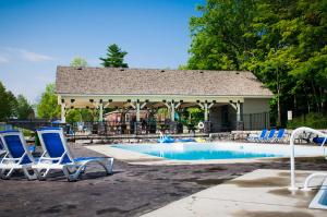 a pool with chairs and a gazebo at 2 Bedroom Cottage Maple Ridge 9 in Gravenhurst