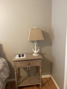 a table with a lamp on it next to a bed at Bay View Condo 3 in Sodus Point