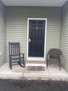 two benches sitting on a porch in front of a door at Bay View Condo 3 in Sodus Point