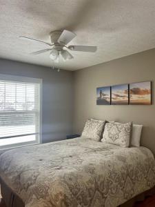 a bedroom with a bed with a ceiling fan at Bay View Condo 3 in Sodus Point