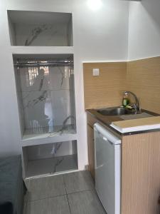 uma pequena cozinha com um lavatório e um frigorífico em Sweetmar Rooms-Ground floor em Cós