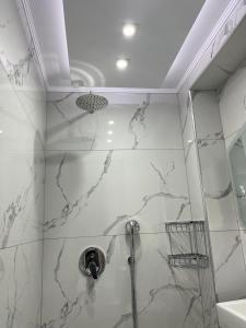 ein Bad mit einer Dusche und Marmorwänden in der Unterkunft Sweetmar Rooms-Ground floor in Kos-Stadt