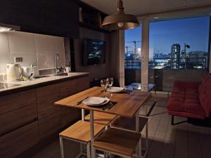 a kitchen with a table with wine glasses on it at NM ApartHotel Tucapel in Concepción