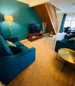 sala de estar con sofá azul y TV en Westwood Drive, en Treharris