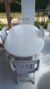 una mesa blanca con cuatro sillas alrededor en chalet en benicasim cerca de la playa, en Benicàssim